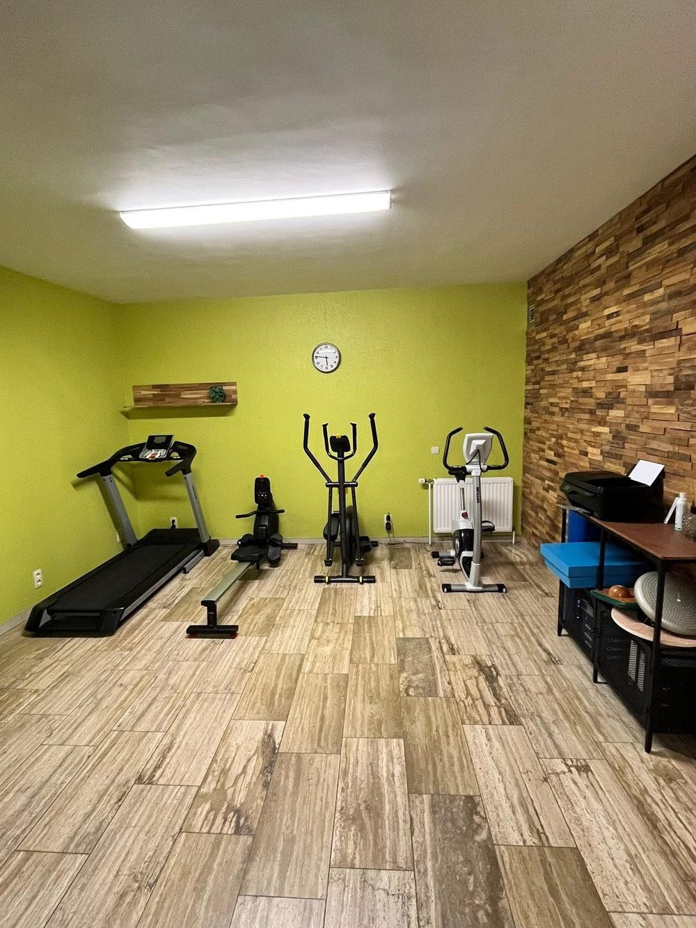 Espace rééducation du cabinet de Paliseul : tapis de course, vélo elliptique et matériel cardio